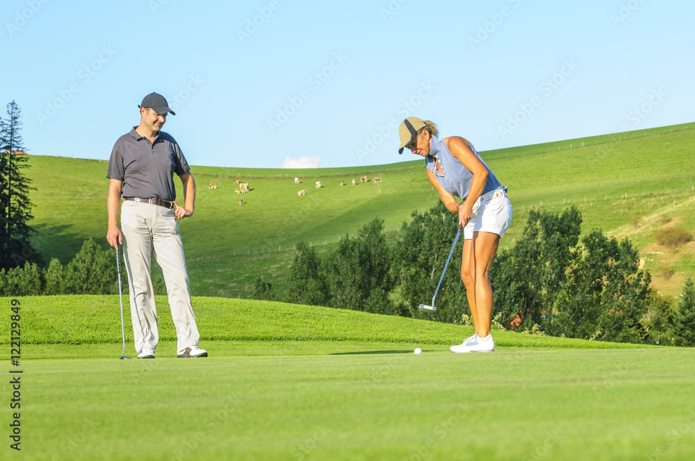 Obraz premium Frau spielt einen Ball ins Loch