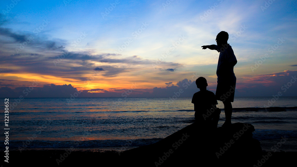 Man Teaching Boy, Silhouette on Beach During Colorful Island Sunset -  - obrazy, fototapety, plakaty 