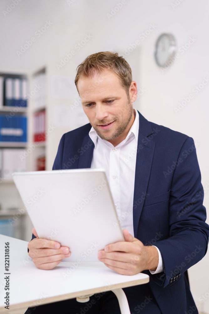 lächelnder mann im büro arbeitet mit tablet lächelnder mann im büro arbeitet mit tablet