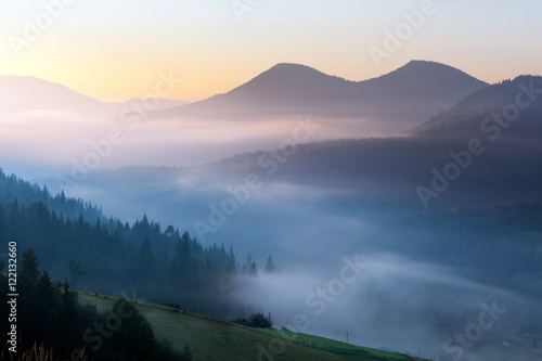 Beautiful foggy landscape in the mountains. Fantastic morning glowing by sunlight.