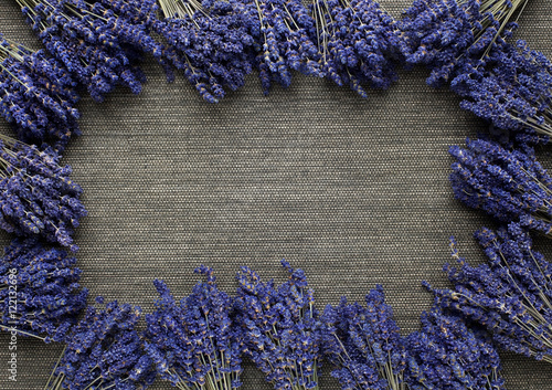 Lavender flower bunch on the dark straw mat. Floral frame.