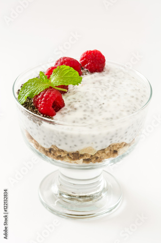 Chia yogurt with raspberries in a glass cup isolated