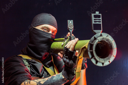 Quadro su tela Man aiming through bazooka gun