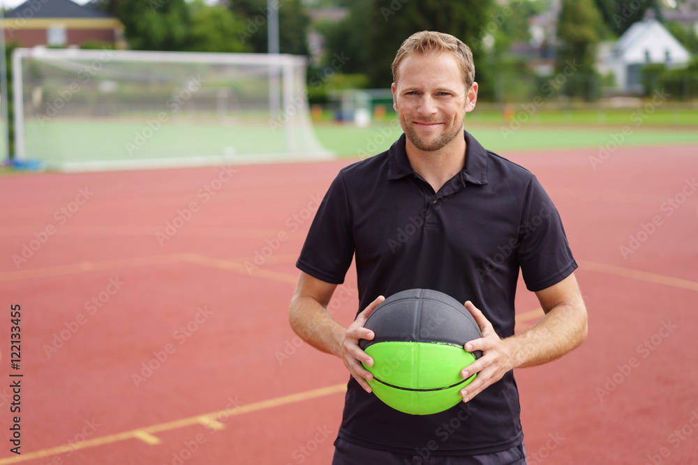 Fototapeta premium mann spielt draußen basketball auf einem sportplatz