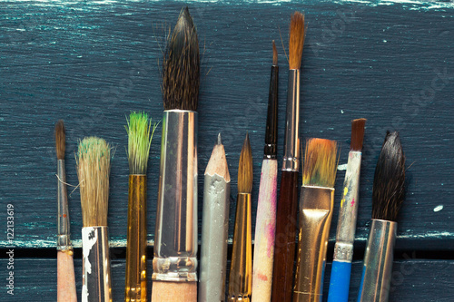 Paint brushes on wooden background