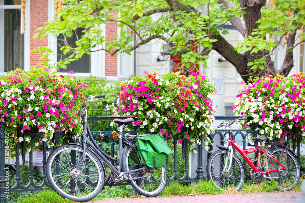 Bicycle leaning on railing of flowers in Amsterdam