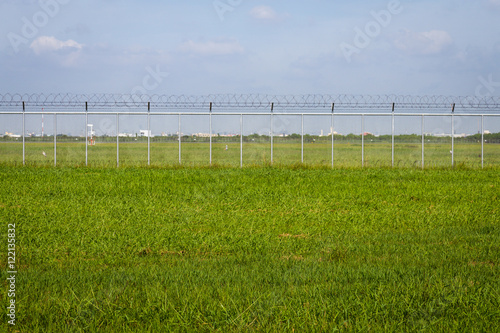 green field and barbed wire fence in jail or security zone
