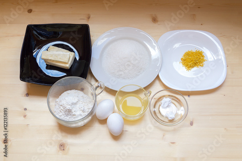Ingredients for lemon muffins on a wooden surface