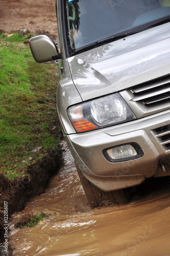 SUV overcomes a pit of mud