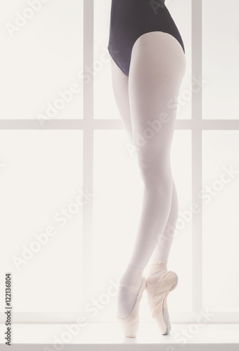 Closeup legs of young ballerina in pointe shoes, ballet practice