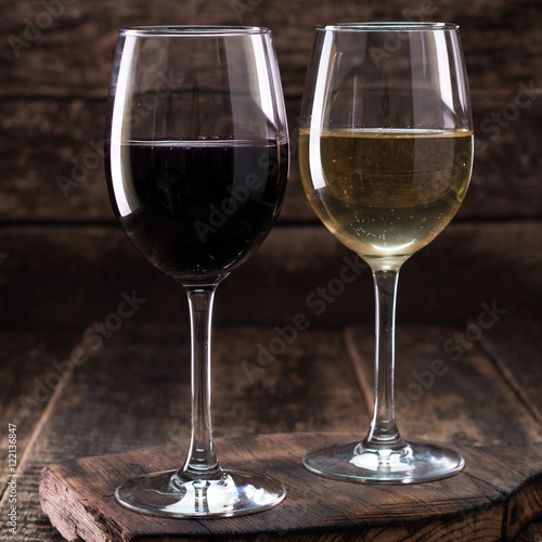 white and red glasses of wine on vintage wooden table