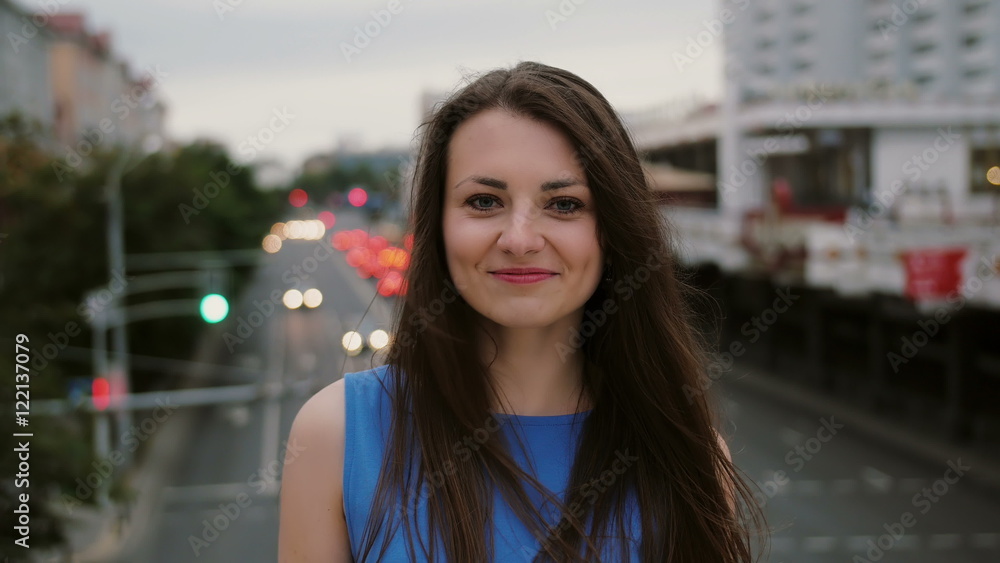Wind blows long dark hair beautiful young women. happy, smiling girl standing on the bridge and looks at the camera. 4K Wind blows long dark hair beautiful young women. happy, smiling girl standing on the bridge and looks at the camera. 4K