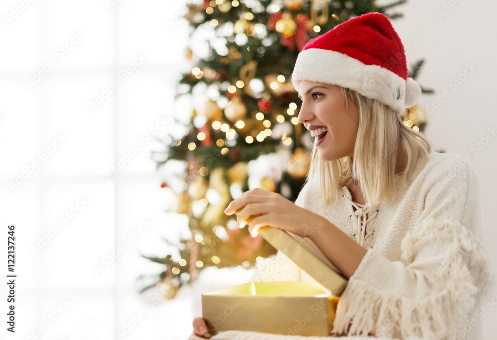 Young woman opening a present on Christmas morning Young woman opening a present on Christmas morning