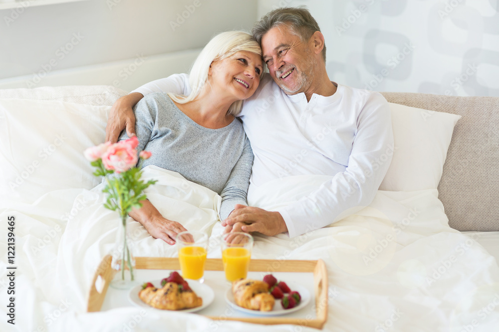 Senior couple enjoying breakfast in bed
