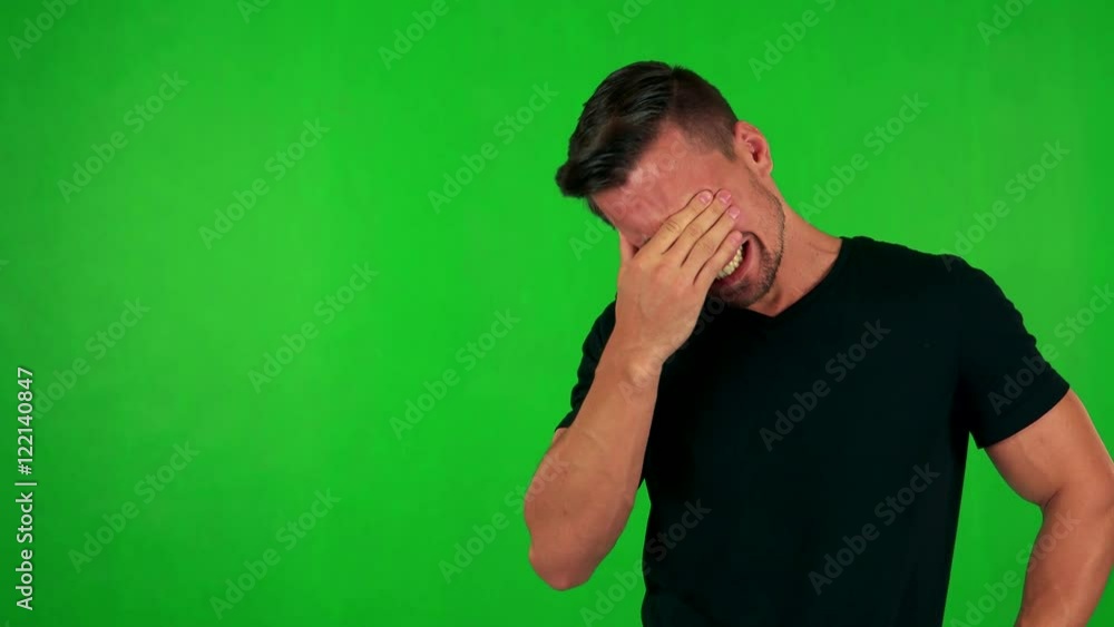 young handsome caucasian man cries - green screen - studio young handsome caucasian man cries - green screen - studio