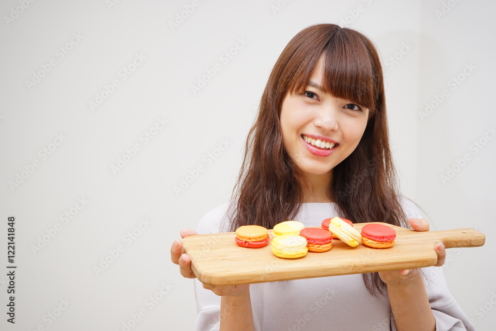 Young Japanese woman holding hand made macaroons Young Japanese woman holding hand made macaroons