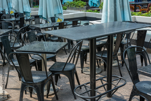 Wooden tables and chairs at the outside of restaurant.