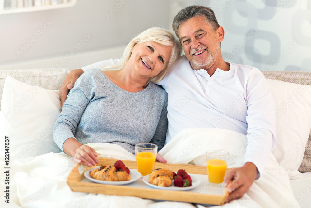 Senior couple enjoying breakfast in bed
