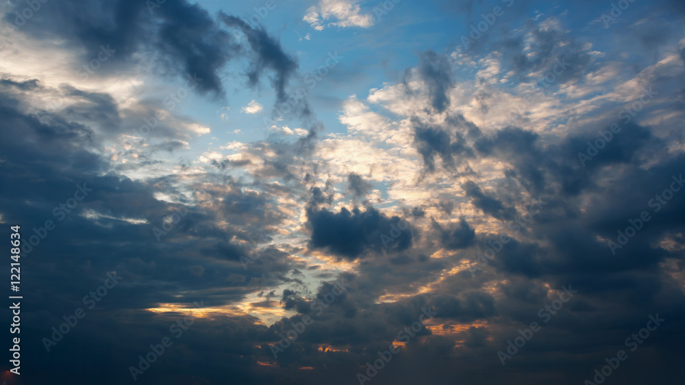 Beautiful autumn evening building clouds with sunset close to night. Clear crisp cloudscape with large, building clouds and light rays, perfect for digital composition background.