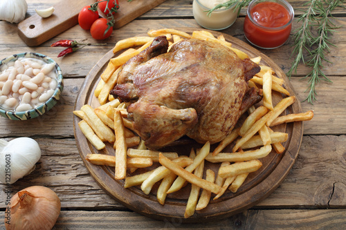 pollo arrosto con patate fritte sfondo tavolo di cucina rustico photo