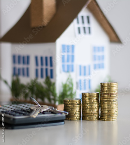 Mortgage concept focused on the coins and keys real estate property with loan money bank concept.