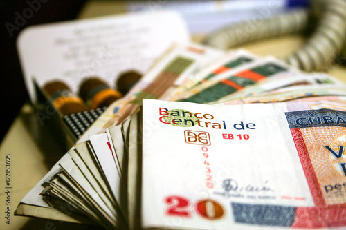 Photography Cuban convertible pesos, with some blurred cigars in the background
