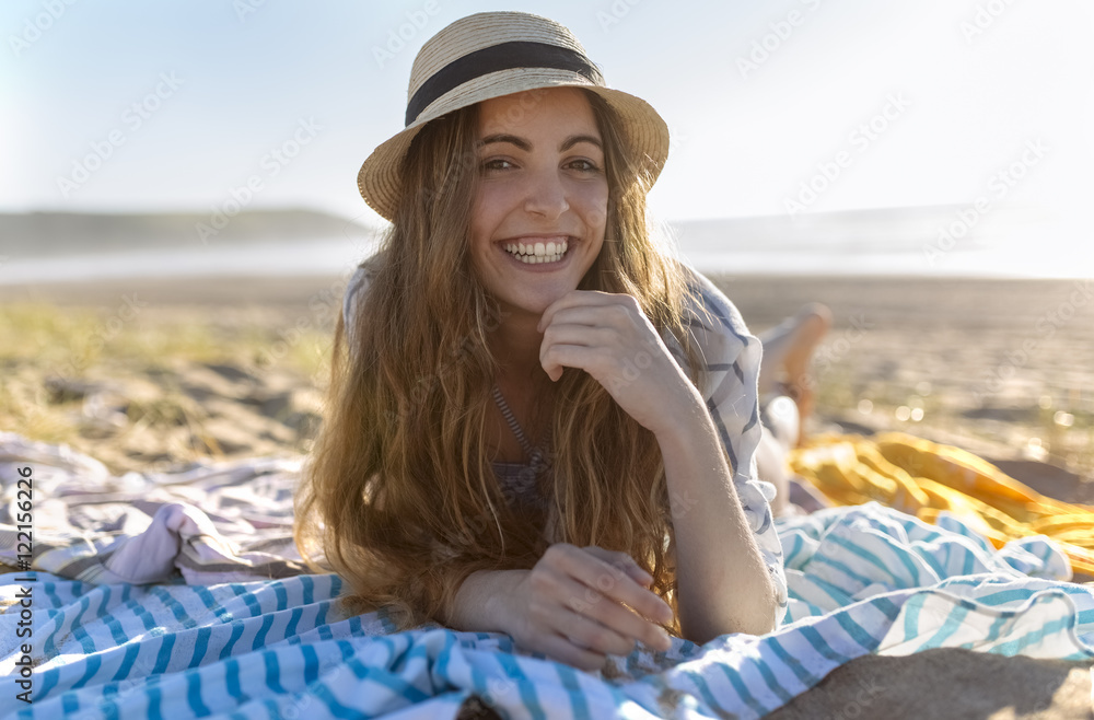 Portrait of smiling teenage girl lying on the beach Portrait of smiling teenage girl lying on the beach