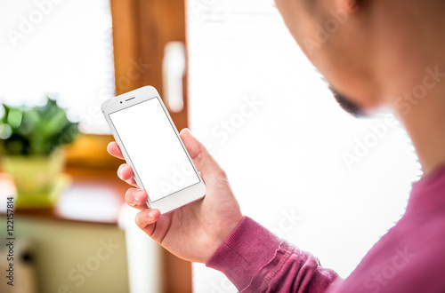 Man using mobile smartphone. Shot with third-person view, behind shoulder, blank screen