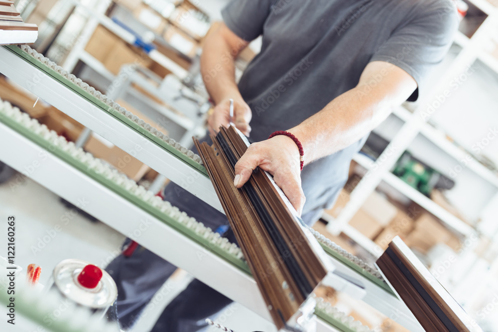 Obraz premium Manual worker assembling PVC doors and windows. Manufacturing jobs. Selective focus. Factory for aluminum and PVC windows and doors production.
