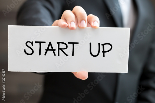 Start up, message on white card and hold by businessman