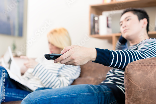 Tableau sur toile Estranged Asian couple reading and watching tv