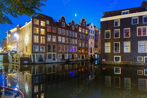 Beautiful typical Dutch houses at the Amsterdam canal at night, Holland, Netherlands.