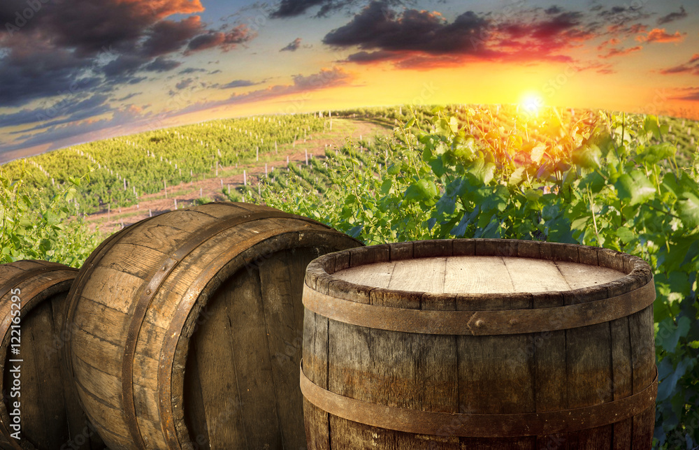 Red wine with barrel on vineyard in green Tuscany, Italy