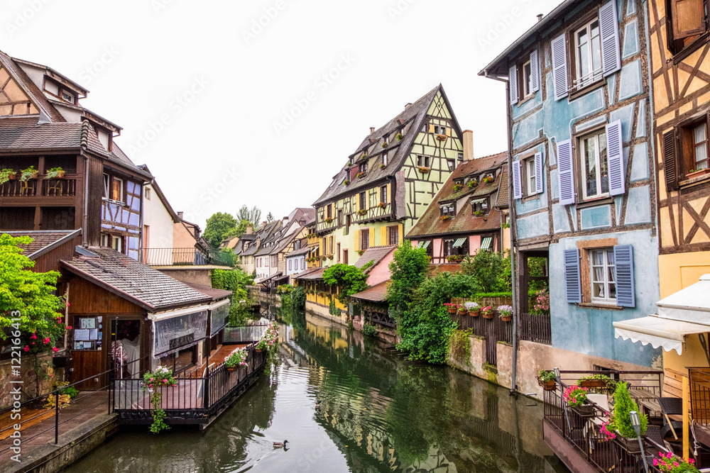  Canal and colorful houses in Petite Venice, Colmar, France. View from bridge in cloudy day.