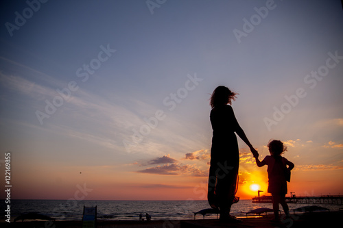 happy mother and daughter having fun at sunset