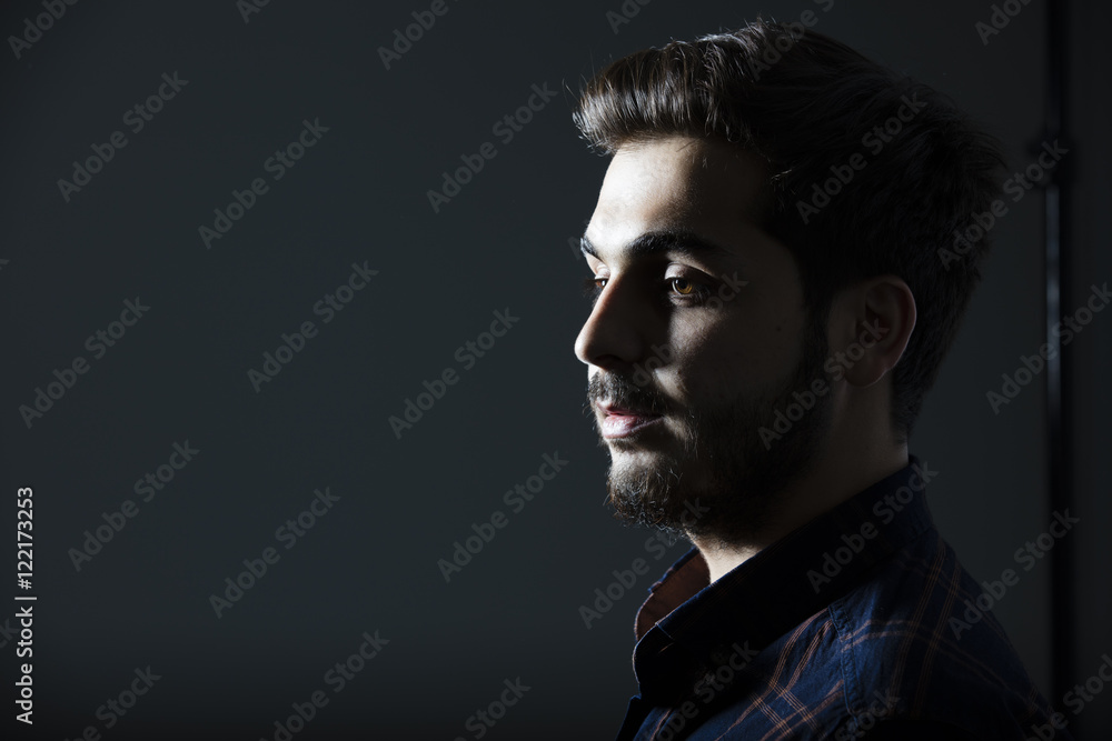 Boy in darkness isolated inside Studio