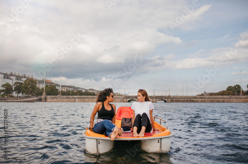 Two young women friends sitting in front pedal boat © Jacob Lund