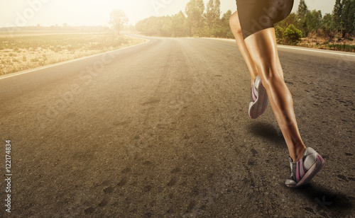 Sports background. Runner feet running on road closeup on shoe.zoom effect