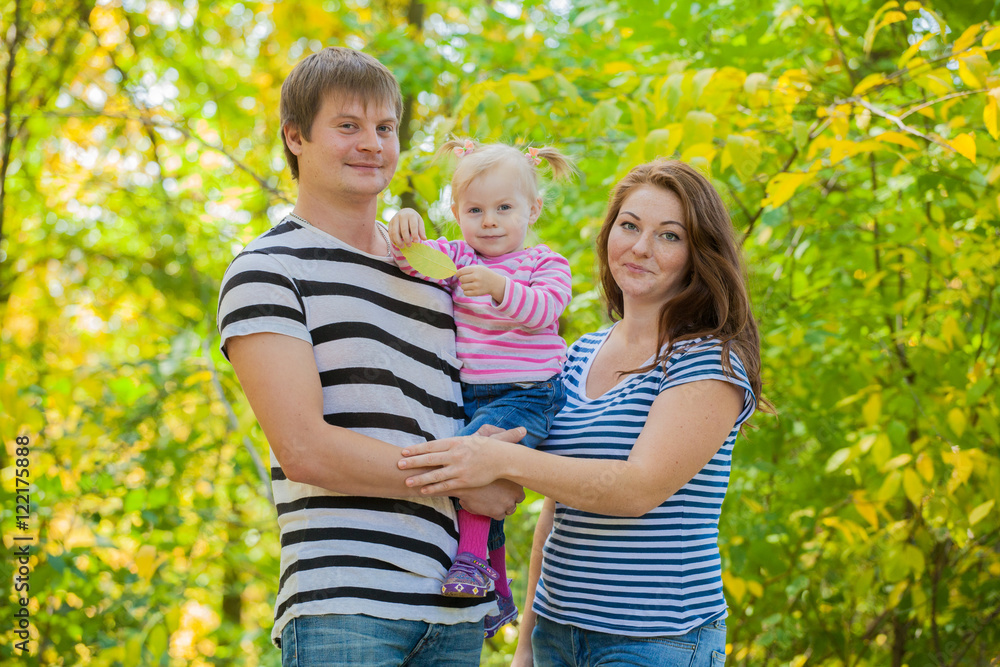 Fototapeta premium happy family in the same clothes for a walk in the park in autumn