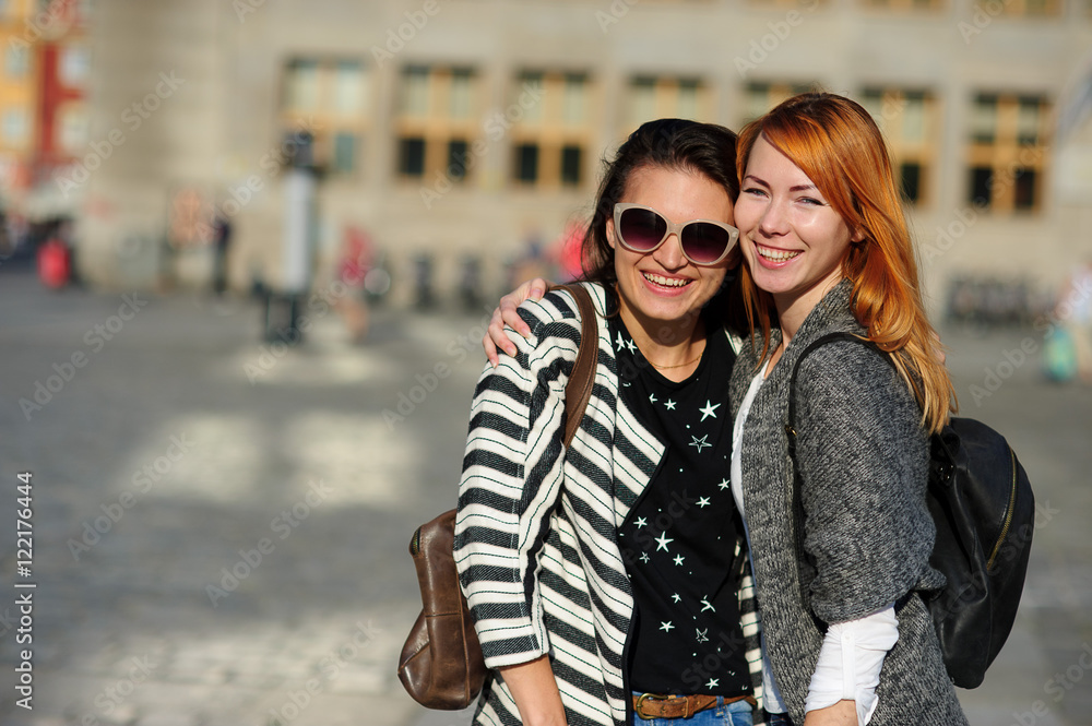 Two nice girls stand in the middle of the paved area having embraced. Two nice girls stand in the middle of the paved area having embraced.