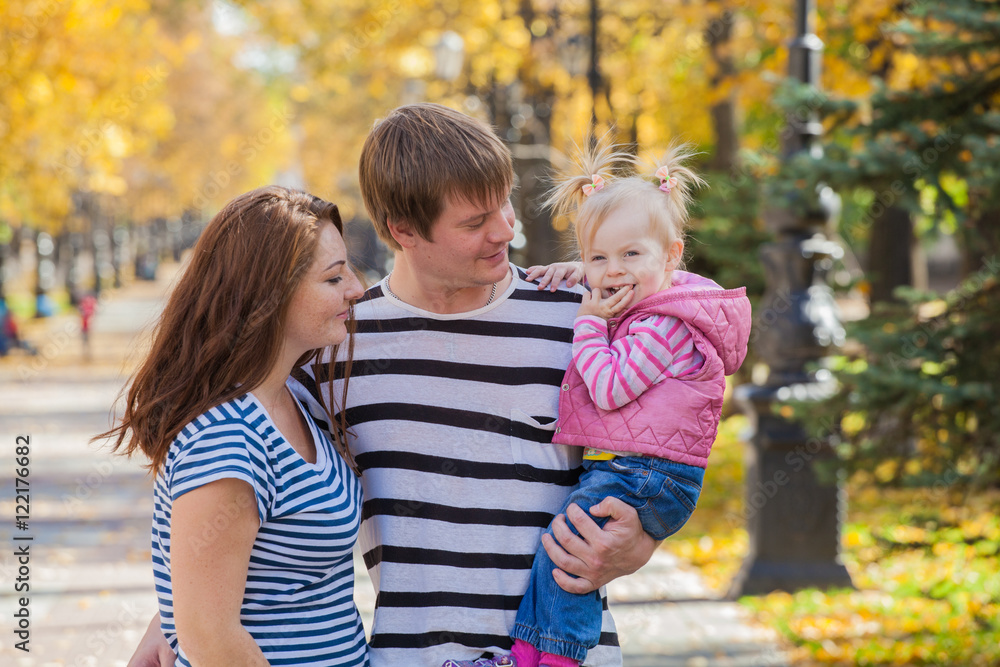 Fototapeta premium happy family in the same clothes for a walk in the park in autumn