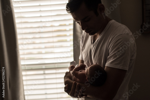 Newborn baby in Hispanic dad's arms