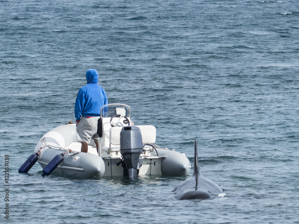 Man in a inflatable rubber boot with outboard motor and a small Stock Photo  | Adobe Stock