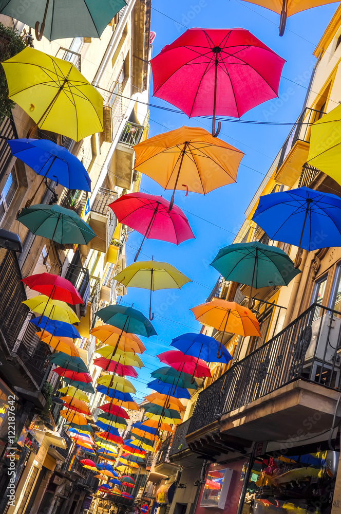 Antique street decorated with colorful umbrellas.