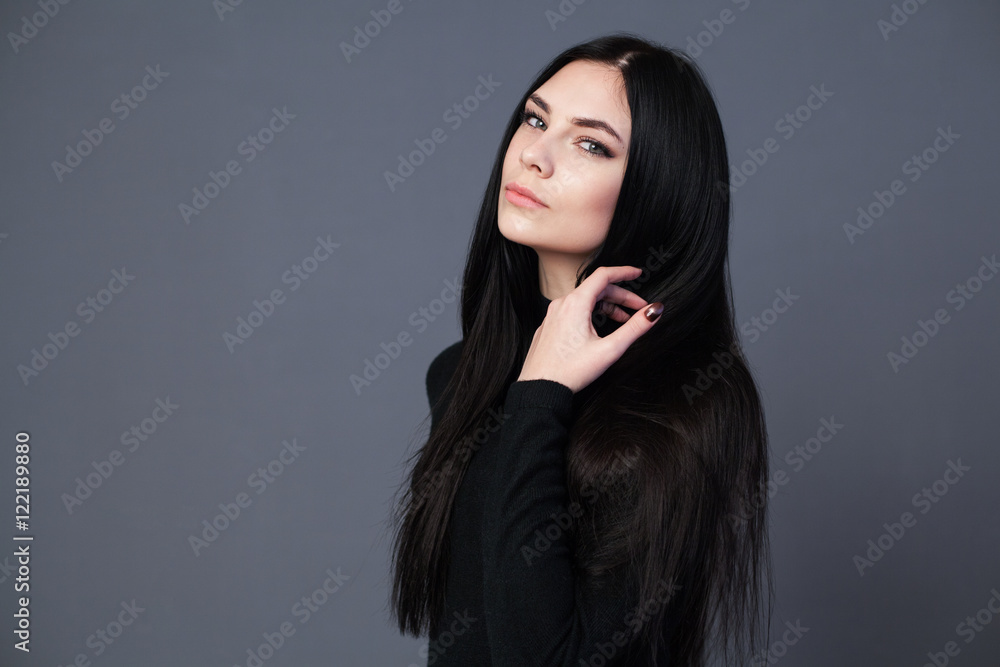 Brunette woman with beautiful long hair, gray background Brunette woman with beautiful long hair, gray background