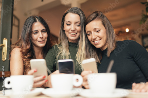 Friends watching social media in a smart phone.