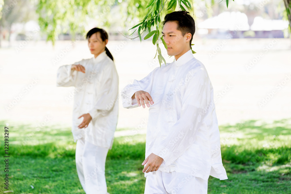 People practicing thai chi in park People practicing thai chi in park
