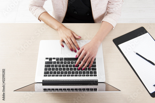 Top view of hand typing on laptop keyboard