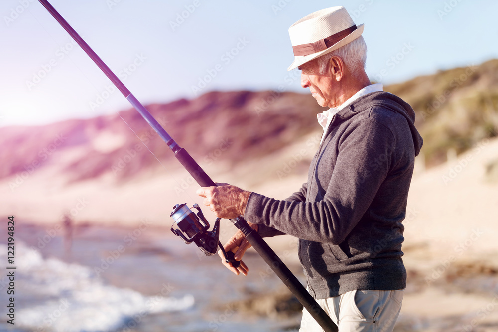 Fototapeta premium Senior man fishing at sea side