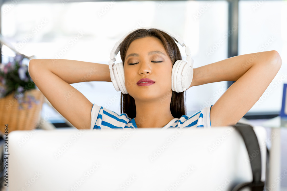 Young woman in office with headphones